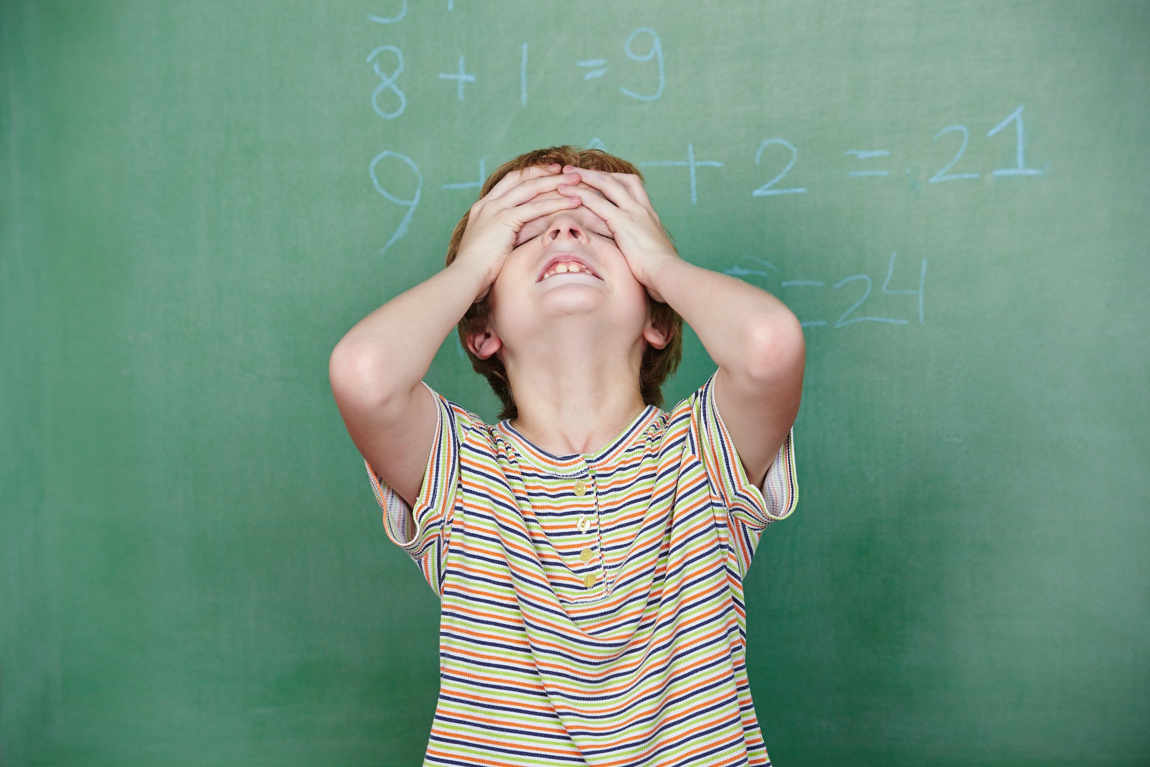 Child with Dyscalculia in Front of Chalkboard